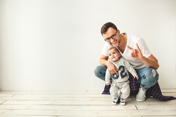 Young hipster father and baby boy on wooden floor